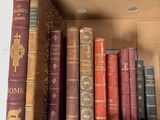 de nombreux livres anciens dans une boîte en carton posée sur l'étagère