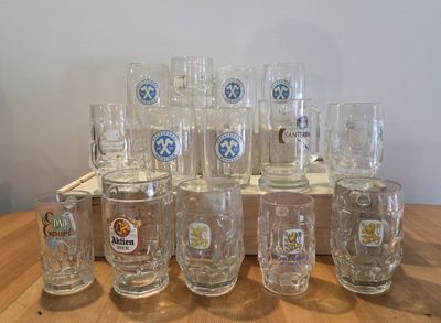 a lot of beer glasses sitting on a wooden table