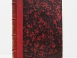 a red and black book sitting on top of a white table
