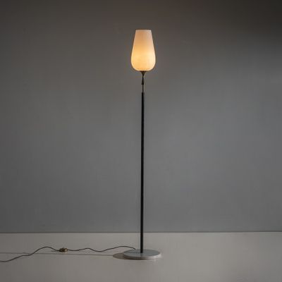 un lampadaire noir surmonté d'un abat-jour blanc