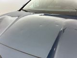 a close up of a car ' s hood on a parking lot