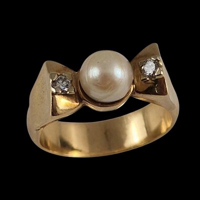 une image représentant une bague en or sertie d'une perle et de diamants