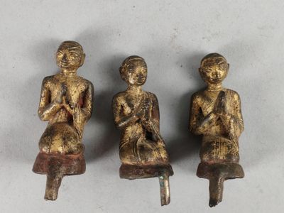 trois figurines en bronze représentant une femme assise sur un tabouret