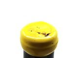 a close up of a bottle of wine with a yellow cap