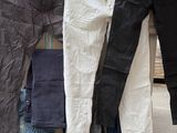 trois paires de jeans suspendues à un portant à l'extérieur