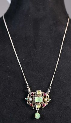 une femme portant un t-shirt noir et un collier composé de perles vertes