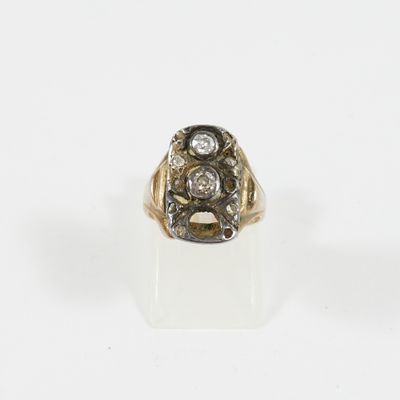 gros plan d'une bague en or et diamants sur une surface blanche