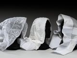 trois mannequins noirs dont la tête est recouverte d'un tissu blanc