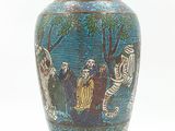 a blue vase with a painting on it on a table