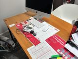 un bureau sur lequel se trouvent un écran d'ordinateur, un clavier et des papiers