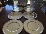 four plates on a table with a vase and a vase in the background