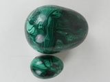 a close up of two green marbles on a white surface