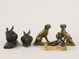trois figurines en bronze représentant des chiens et un chat, posées sur un socle en marbre
