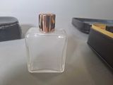a bottle of perfume sitting on a table next to a purse