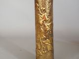 a gold vase with a design on it on a table