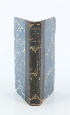a blue book with a black cover on a white surface