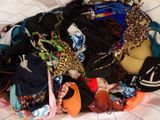 a pile of clothes that is laying on a bed
