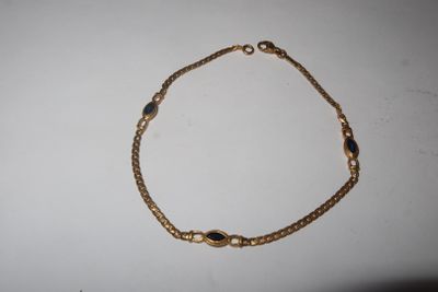 a close up of a gold bracelet on a white surface