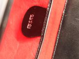 a red and black bag with a tag on it