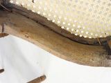 a close up of a wooden chair with holes on the back