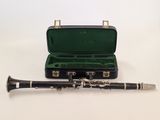 a black and silver clarinet in a case on a white surface