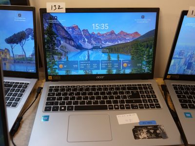 three laptops are sitting on a table with a price tag on them
