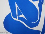 a blue and white drawing of a woman sitting on a chair
