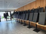 des rangées de chaises noires alignées les unes à côté des autres dans une pièce