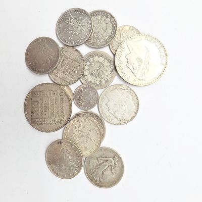 quelques pièces d'argent posées sur une surface blanche, sur fond blanc