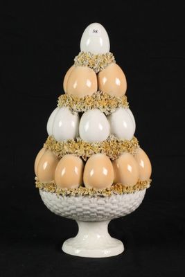 a white vase with eggs in it on a black background