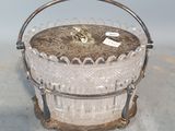a small glass basket with a handle on a table