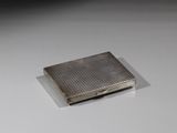 un petit étui à cigarettes en argent posé sur une table