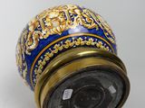 a blue and gold vase sitting on a white surface