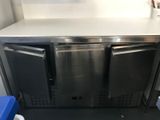 a stainless steel counter top with two refrigerators on it