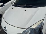 a white car parked in a parking lot with other cars in the background