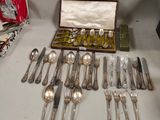 a lot of silver spoons and forks in a box