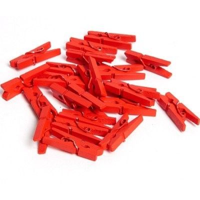 many red clothes pegs on a white surface