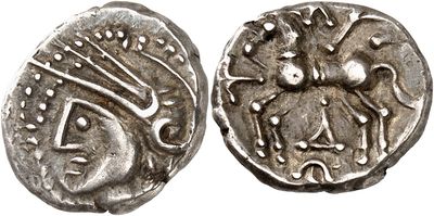 a close up of a silver coin with a face on it