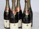 four bottles of wine are lined up on a marble table