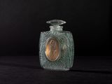a small glass bottle with a gold coin in it