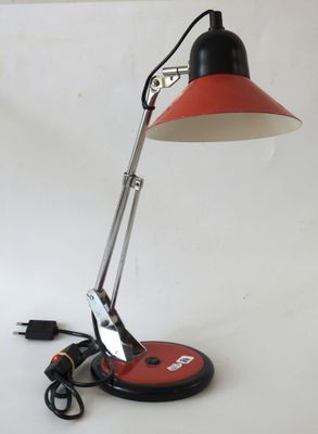 an image of a red and black desk lamp on a white surface
