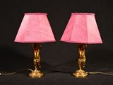 une paire de lampes roses posées sur une surface noire, sur fond noir