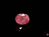 gros plan d'un diamant rose sur une surface noire