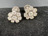 a pair of diamond earrings on a black surface