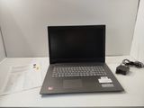 a laptop computer sitting on a desk with a charger on it