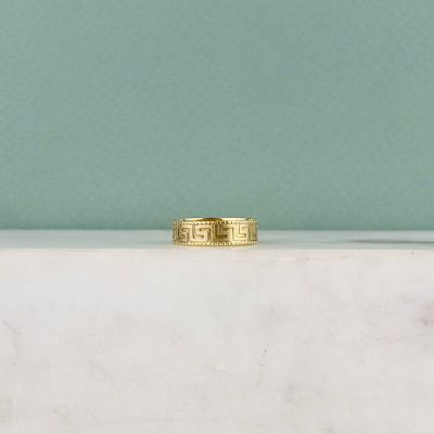 une bague en or posée sur un comptoir en marbre blanc