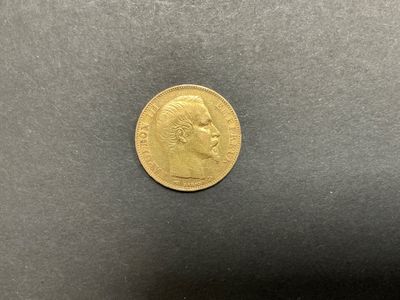 gros plan d'une pièce d'or sur une surface noire