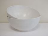 un bol blanc posé sur une table, avec une cuillère à l'intérieur