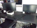 two computer monitors and a keyboard on a desk