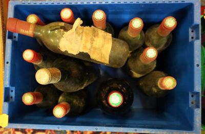 many bottles of wine in a blue crate on a table